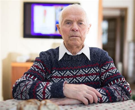Serious Elderly Man Sitting Alone At Table During Christmas Holidays