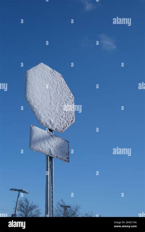 A Layer Of Snow Covers The Face Of A Stop Sign After A Winter Storm