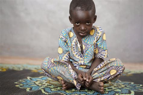 Sad Little African Boy Looking At Camera With Blurred Background Stock