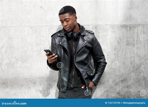 Handsome Young Black Man In Leather Jacket Looking On Cellhphone Stock
