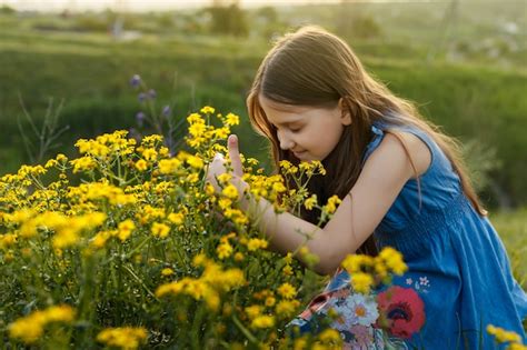 Premium Photo Little Girl Smelling A Yellow Flower
