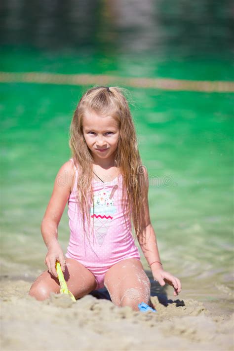 Прелестная маленькая девочка на пляже во время лета Стоковое Фото изображение насчитывающей