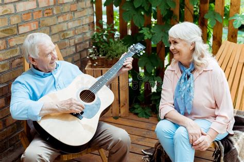Retired Woman Looking At Husband Playing Acoustic Guitar Stock Image Image Of Looking