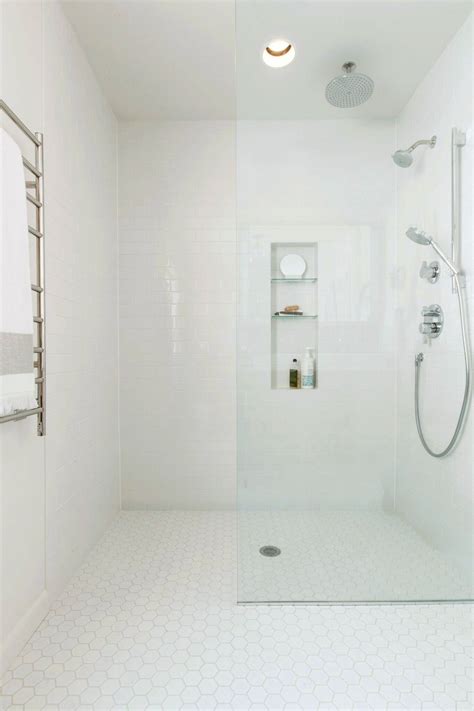 A White Bathroom With A Shower Toilet And Shelf On The Wall Next To It