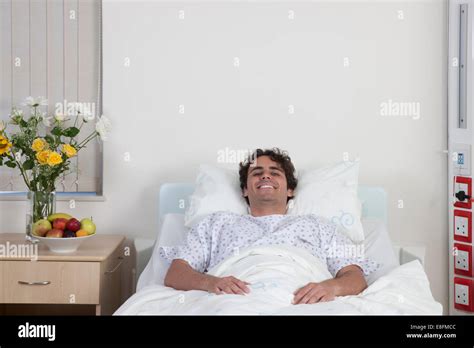 Smiling Man In Recovery Lying In Hospital Bed On Hospital Ward Stock