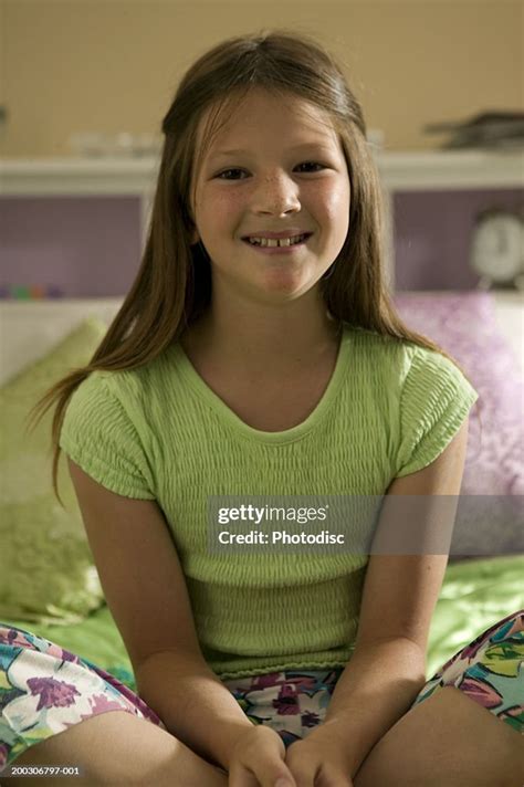 Young Girl Sitting On Bed Crossing Legs Closeup High Res Stock Photo