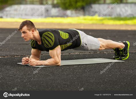 Fitness Man Doing Planking Exercise In The Stadium Muscular Male