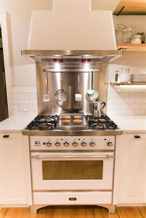 It's certainly not as subtle and hidden as a range hood insert, but it puts the modern in modern farmhouse kitchen! White Ilve range with hood and backsplash. 36'' White ...
