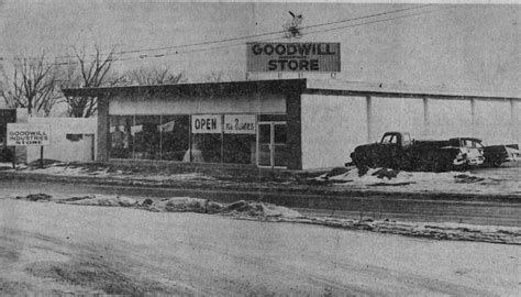 An Old Black And White Photo Of A Store With Cars Parked In Front Of It