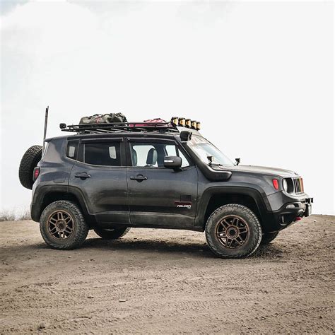 A Gray Jeep Parked On Top Of A Dirt Field