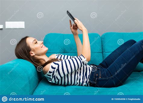 Attractive Woman Smiling As She Reads An Sms Message On Her Mobile