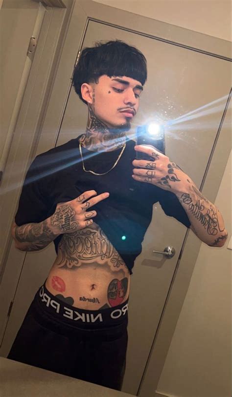 A Man Taking A Selfie In The Mirror With His Cell Phone And Tattoos On