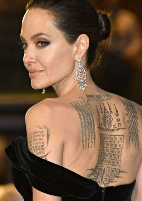 The Back Of A Womans Neck With Tattoos On Her Chest And Shoulder