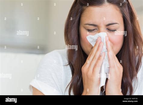 Burnette Woman Blowing Nose Into Tissue Stock Photo Alamy