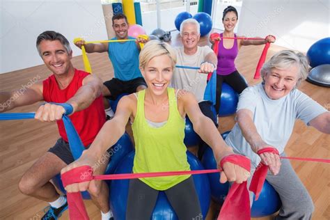 Happy People Exercising With Resistance Bands In Gym Class Stock Photo