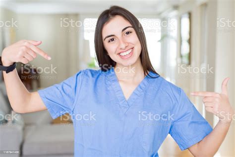 Beautiful Young Nurse Woman At The Clinic Looking Confident With Smile