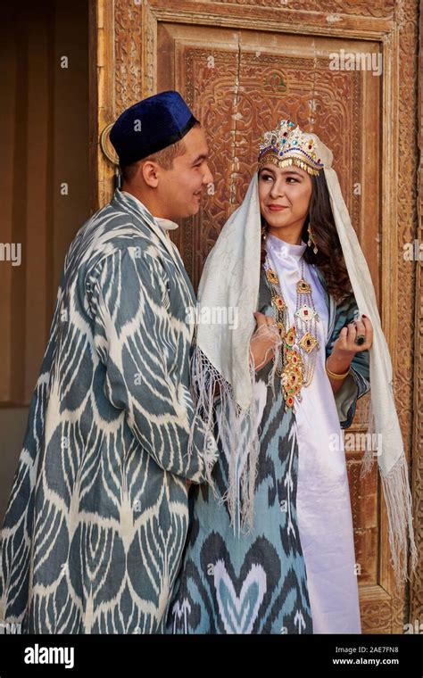 Bridal Couple In Traditional Clothes Posing In Front Of Famous Registan Square Samarkand