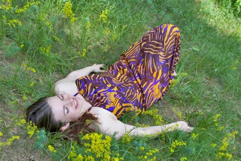 Jolie jeune femme allongée sur la pelouse de la forêt image libre de