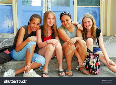 Portrait Of A Group Of Young Smiling School Girls Sitting On Steps Near School Building Zdjęcie