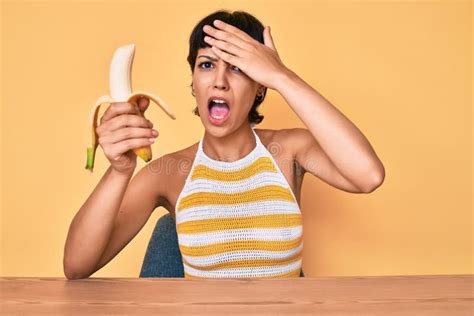 Brunette Teenager Girl Eating Banana As Healthy Snack Stressed And