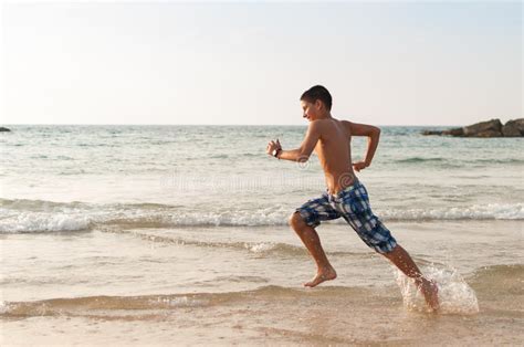 El Muchacho Adolescente Est Corriendo A Lo Largo De La Playa Foto De