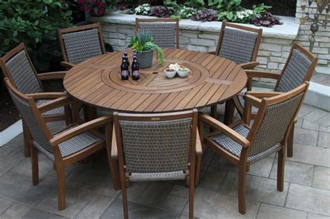 A Wooden Table With Chairs Around It In The Middle Of A Patio Area Next