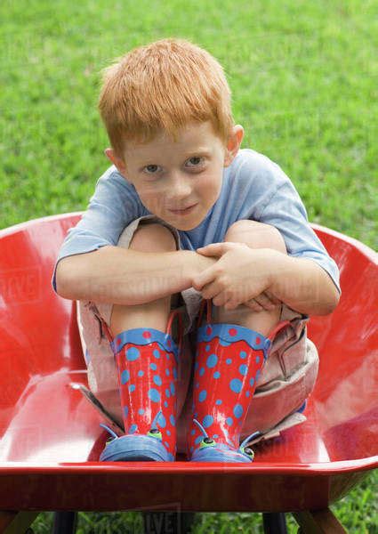 Little Boy Sitting In Wheelbarrow Stock Photo Dissolve
