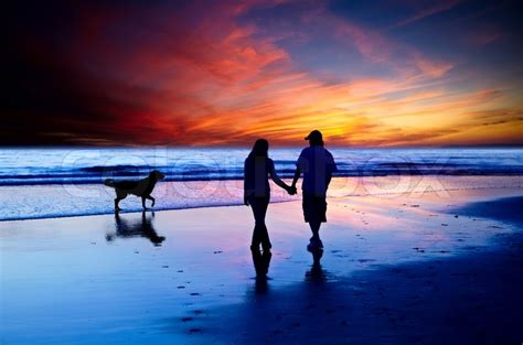 Young Couple In Love Walking On The Beach With Golden