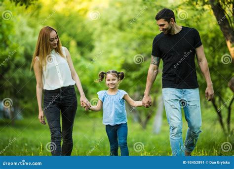 Madre Padre Feliz Y Niña Caminando En Parque Del Verano Y