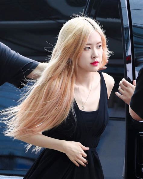 A Woman With Long Blonde Hair Standing Next To A Car