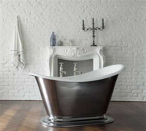 A stunning cast iron freestanding bathtub sits beside a folding screen positioned covering a window located in an accent wall framed by taupe herringbone wall tiles perfectly accenting white side walls in this refined tub nook. Drummonds Morar bath | Cast iron bath, Cast iron bathtub ...