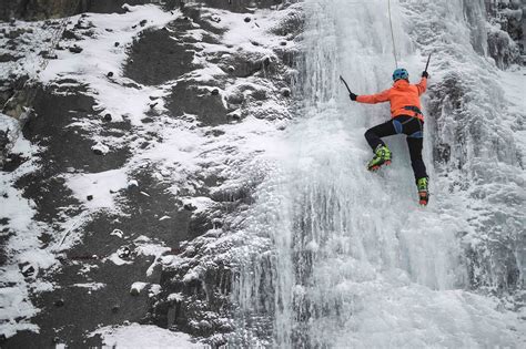 People Climb An Artificial Frozen Waterfall At A Ski Resort In Metabief