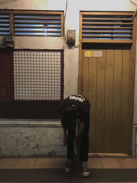 A Person Bending Over In Front Of A Door