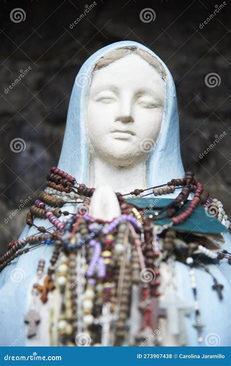 Statue Of The Virgin Mary With Many Rosaries Hanging From Her Neck And