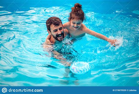 Father And Son Playing Together In The Swimming Pool Stock Photo