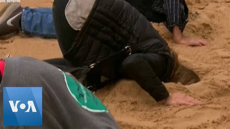 Climate Activists Bury Their Heads In Sand In Australia