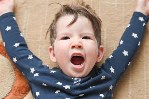 Portrait Of Boy Yawning While Lying On The Floor Cute Caucasian