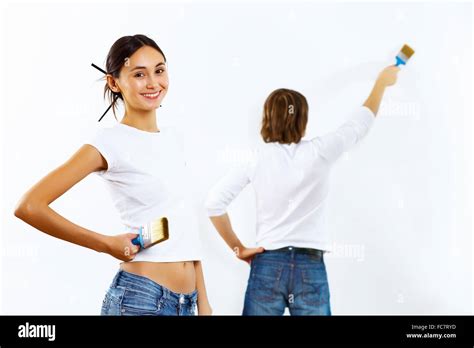 Young Couple With Paint Brushes Doing Renovation Together Stock Photo