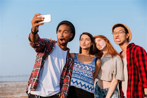 Group Of Amusing Young Friends Taking Selfie With Cell Phone And Making