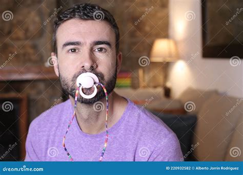 Spoiled Grown Up Man Licking A Pacifier To Control A Tantrum Stock