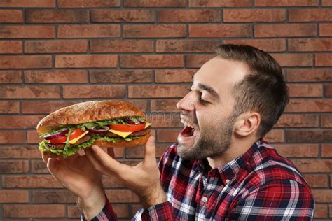 Young Hungry Man Eating Tasty Sandwich Stock Photo Image Of Lettuce