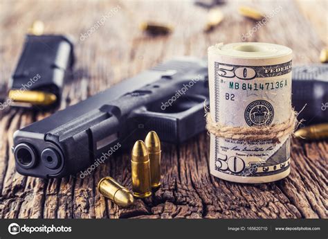 Gun And Money 9 Mm Pistol Gun Bullets Strewn And Roll Dollar Banknotes