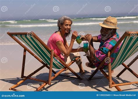 Senior Couple Relaxing On Sun Lounger And Drinking Cocktail On Beach Stock Image Image Of 6569