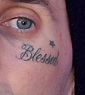 "Blessed" lettering tattoo on Travis Barker's face.