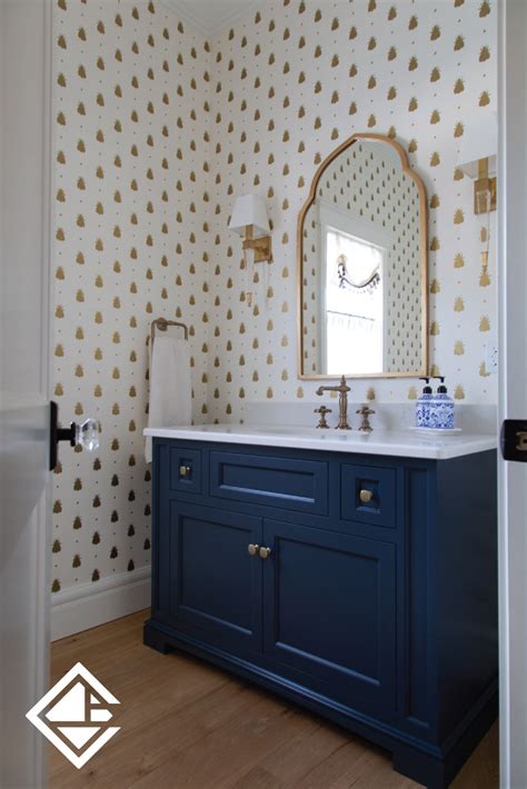 this navy blue custom vanity provides the perfect contrast to the statement wallpaper behind it