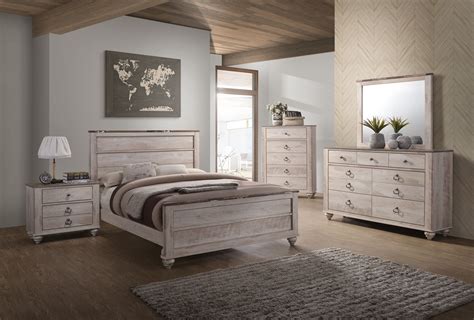 The upholstered headboard features button tufted accents while the storage footboard offers padding on top. Antique White Washed Walnut Four Piece Bedroom Set