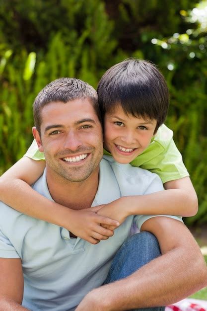 Premium Photo Father With His Son Hugging In The Garden