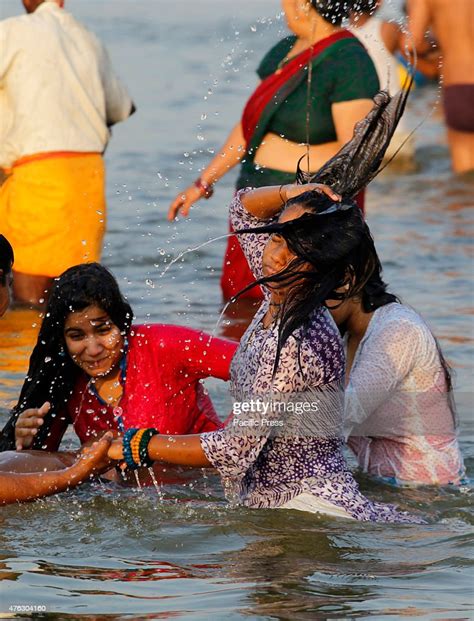 girls taking a bath in the waters of the river ganges during a hot