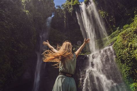 Woman In Turquoise Dress At The Sekumpul Waterfalls In Jungles On Bali