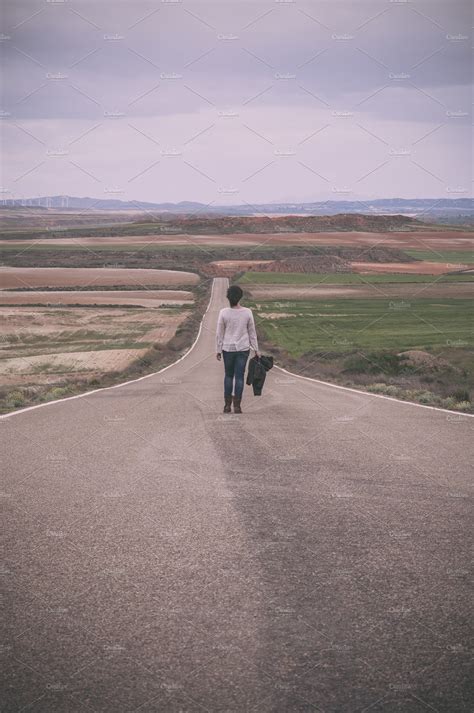 Woman walking alone in a road featuring woman, walking, and landscape | High-Quality People ...